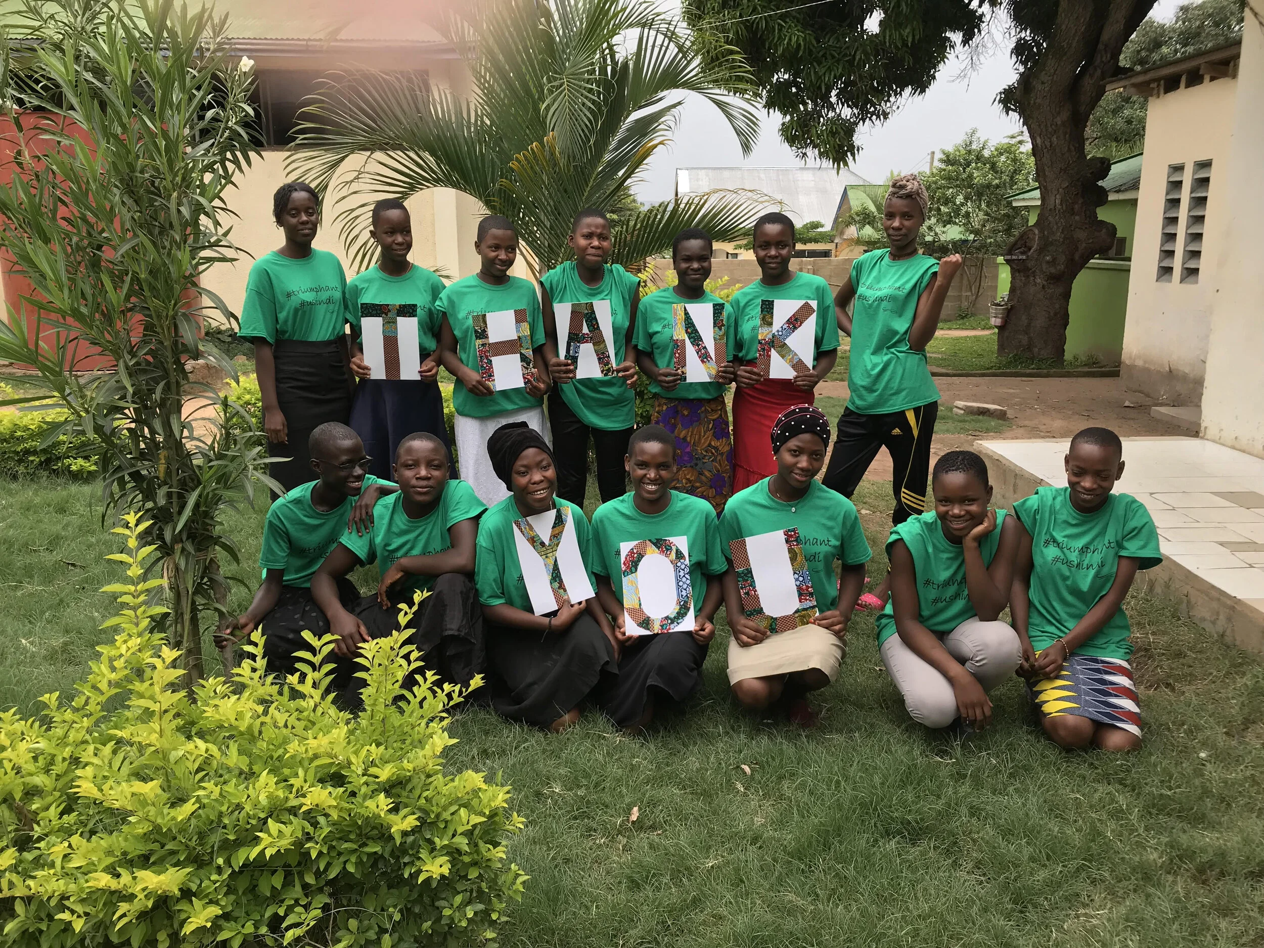 Youth at Uzima Center holding letters that spell THANK YOU